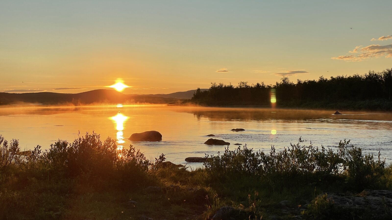 Solnedgang over vann i Finnmark